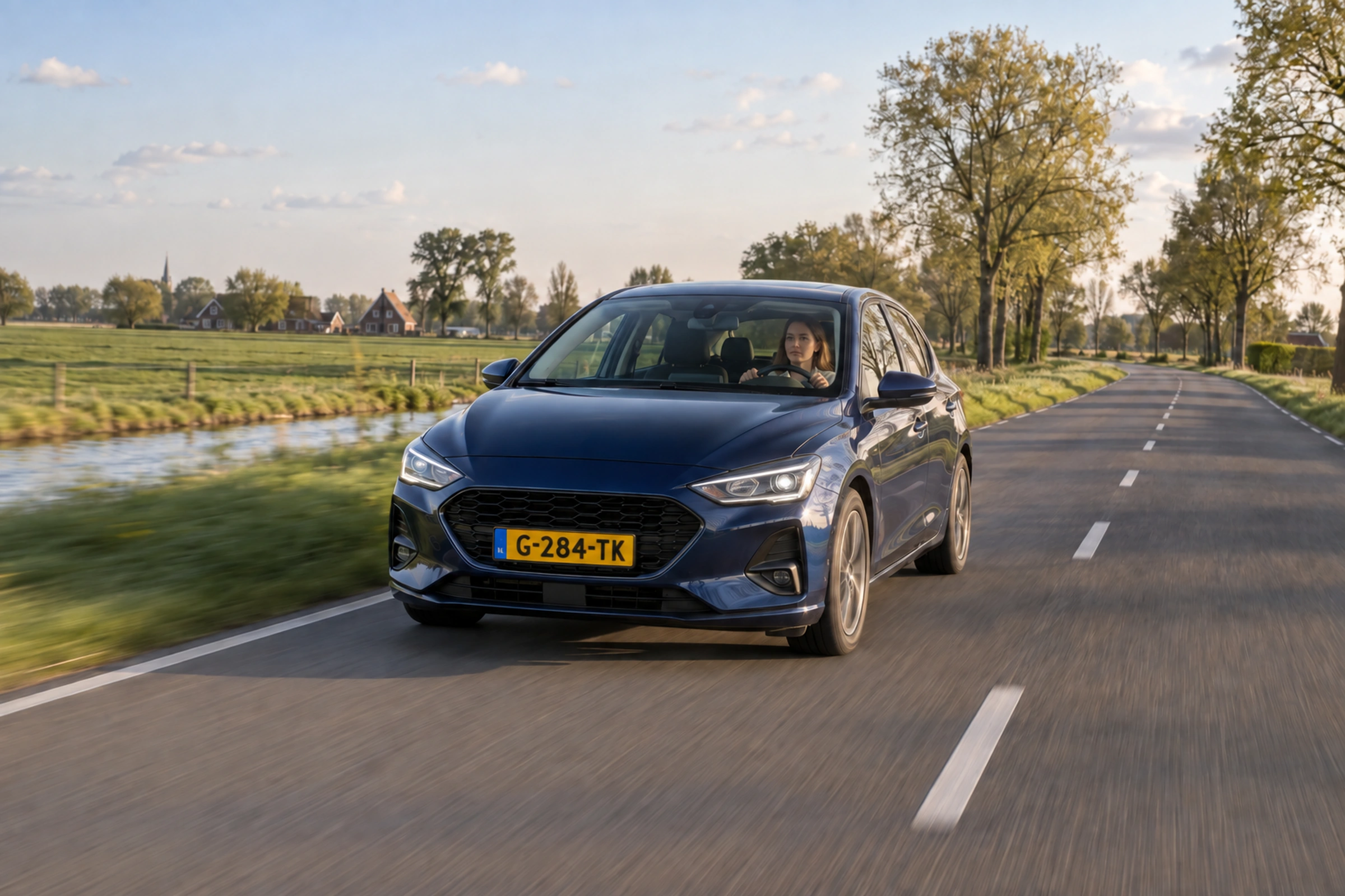 Auto rijdt over een Nederlandse weg.